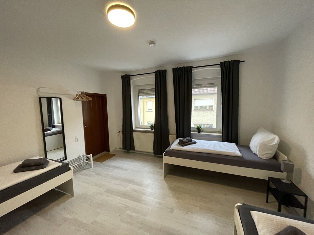 Schlafzimmer mit 3 Einzelbetten und Handtüchern