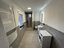 Badezimmer mit Dusche und WC sowie Waschmaschine