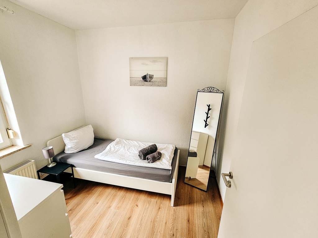 Schlafzimmer mit einem Einzelbett und Handtüchern