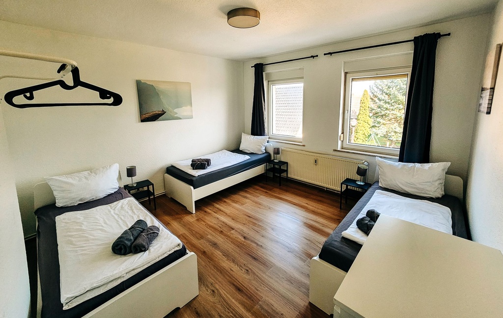 Schlafzimmer mit 3 Einzelbetten und Handtüchern