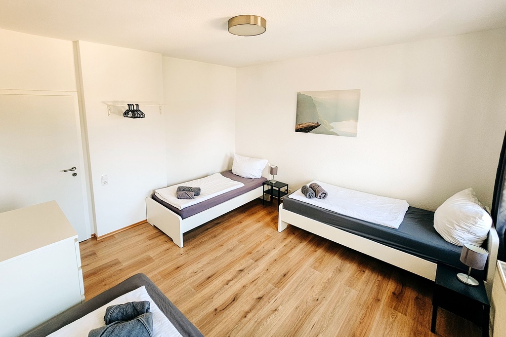Schlafzimmer mit 3 Einzelbetten und Handtüchern