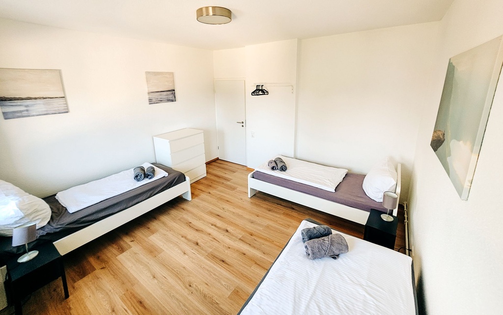 Schlafzimmer mit 3 Einzelbetten und Handtüchern