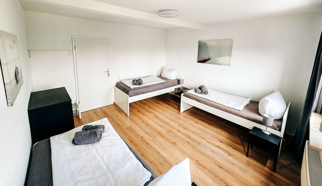 Schlafzimmer mit 3 Einzelbetten und Handtüchern