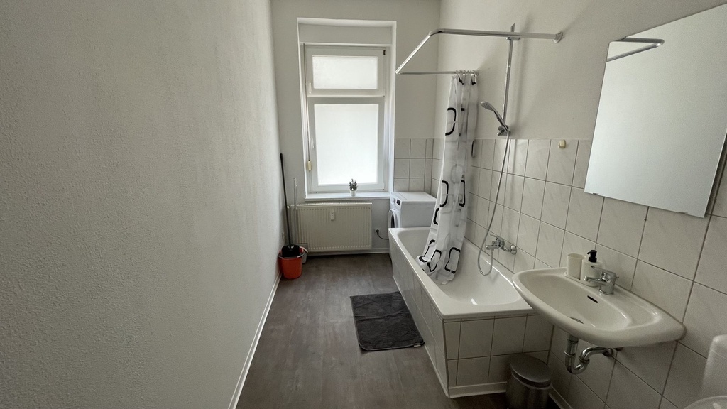 Badezimmer mit Badewanne/Dusche und WC und Waschmaschine