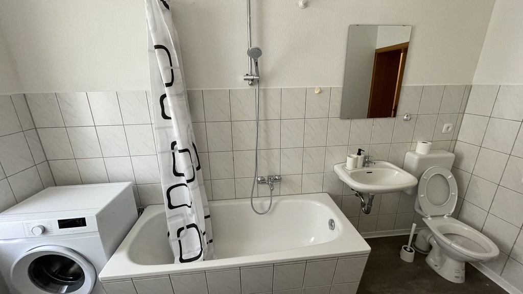 Badezimmer mit Badewanne/Dusche und WC und Waschmaschine