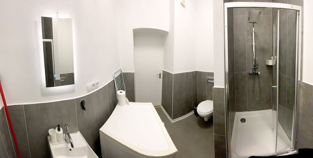 Badezimmer mit Badewanne/Dusche und WC und Waschmaschine
