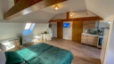 Schlafzimmer mit Doppelbett und Schreibtisch sowie Schlafcouch