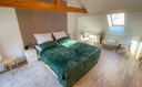 Schlafzimmer mit Doppelbett und Schreibtisch sowie Schlafcouch