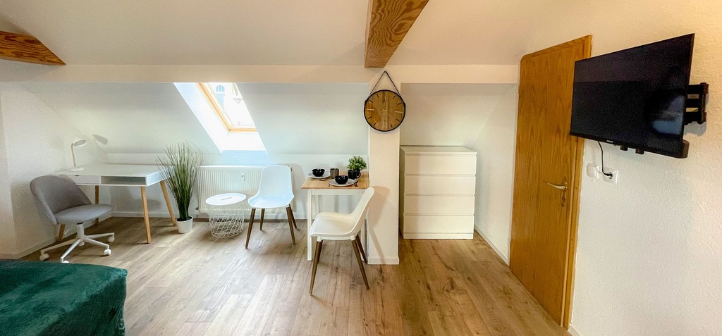Schlafzimmer mit Doppelbett und Schreibtisch sowie Schlafcouch