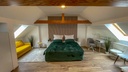 Schlafzimmer mit Doppelbett und Schreibtisch sowie Schlafcouch