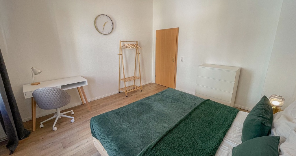 Schlafzimmer mit Doppelbett und Schreibtisch