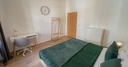 Schlafzimmer mit Doppelbett und Schreibtisch