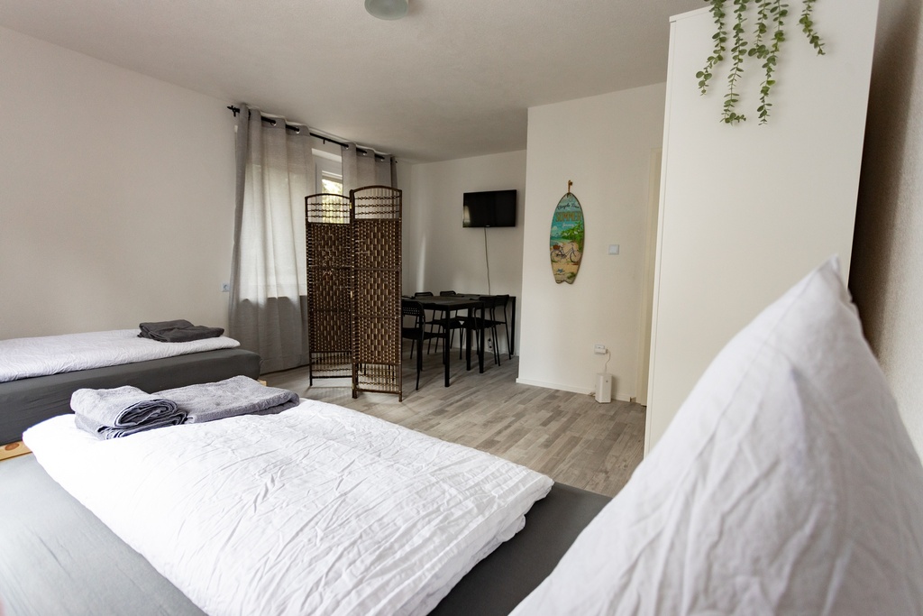 Schlafzimmer mit 2 Einzelbetten und Handtüchern sowie Smart-TV