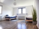 großes Schlafzimmer mit zwei Einzelbetten und Smart-TV