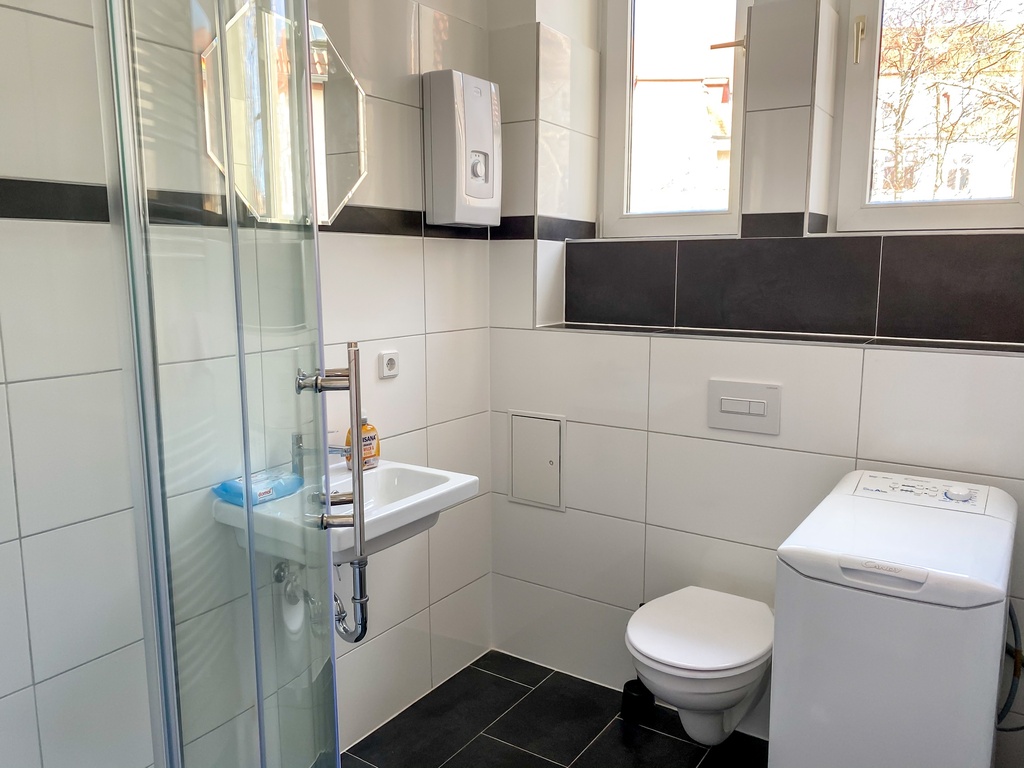 Badezimmer mit Dusche und Waschmaschine
