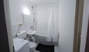 Badezimmer mit Badewanne/Dusche und WC und Waschmaschine